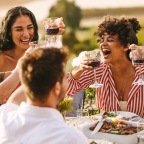 a group of people sitting at a table with food and drinks
