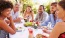 a group of people sitting around a table eating food